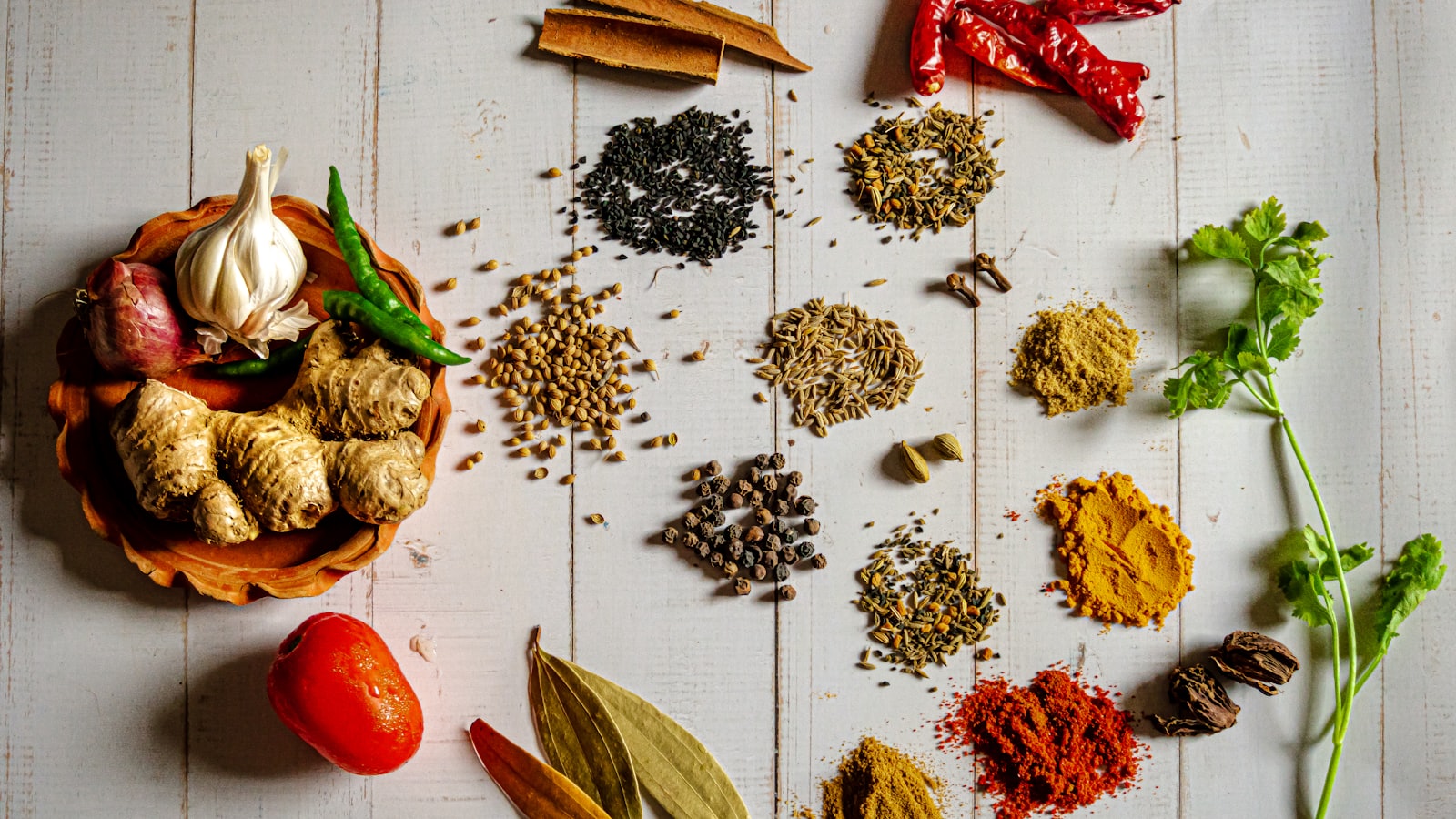 Whole spices laid out on a white table